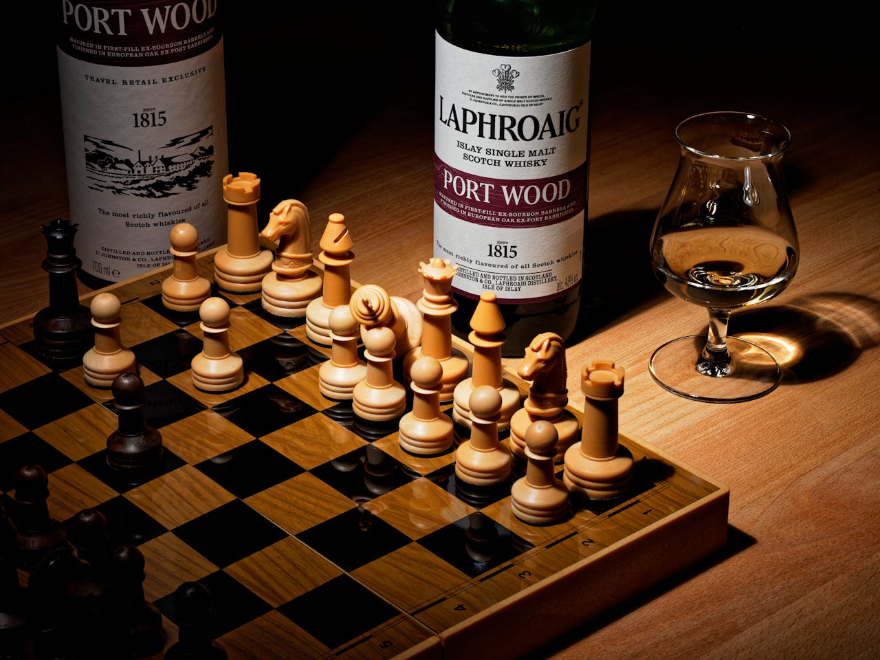 Premium chess board and whiskey bottles on wood table